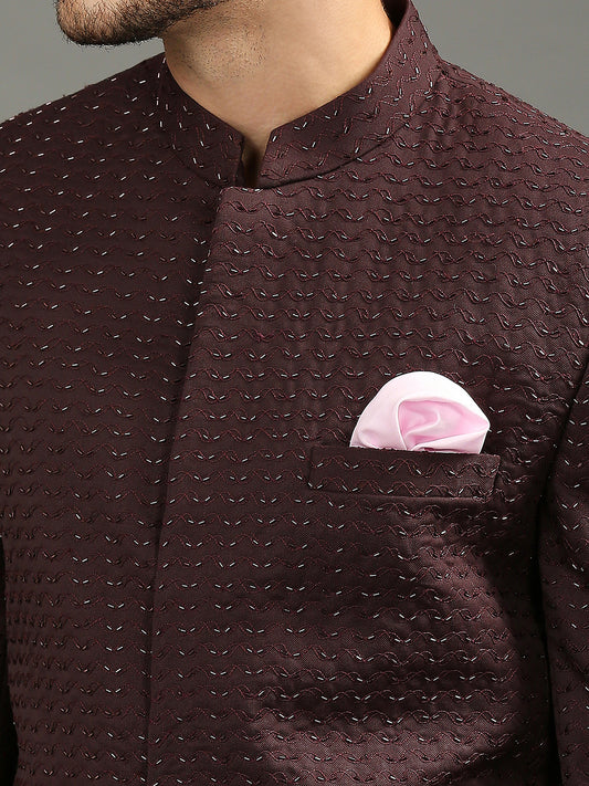 Featuring a wine-colored bandhgala adorned with intricate cutdhana handwork, this ensemble is paired with classic black formal pants. A refined yet festive statement, it's the perfect choice for a sangeet.