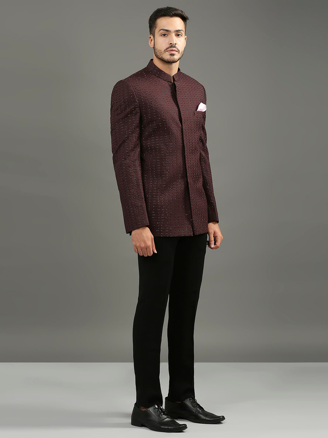 Featuring a wine-colored bandhgala adorned with intricate cutdhana handwork, this ensemble is paired with classic black formal pants. A refined yet festive statement, it's the perfect choice for a sangeet.
