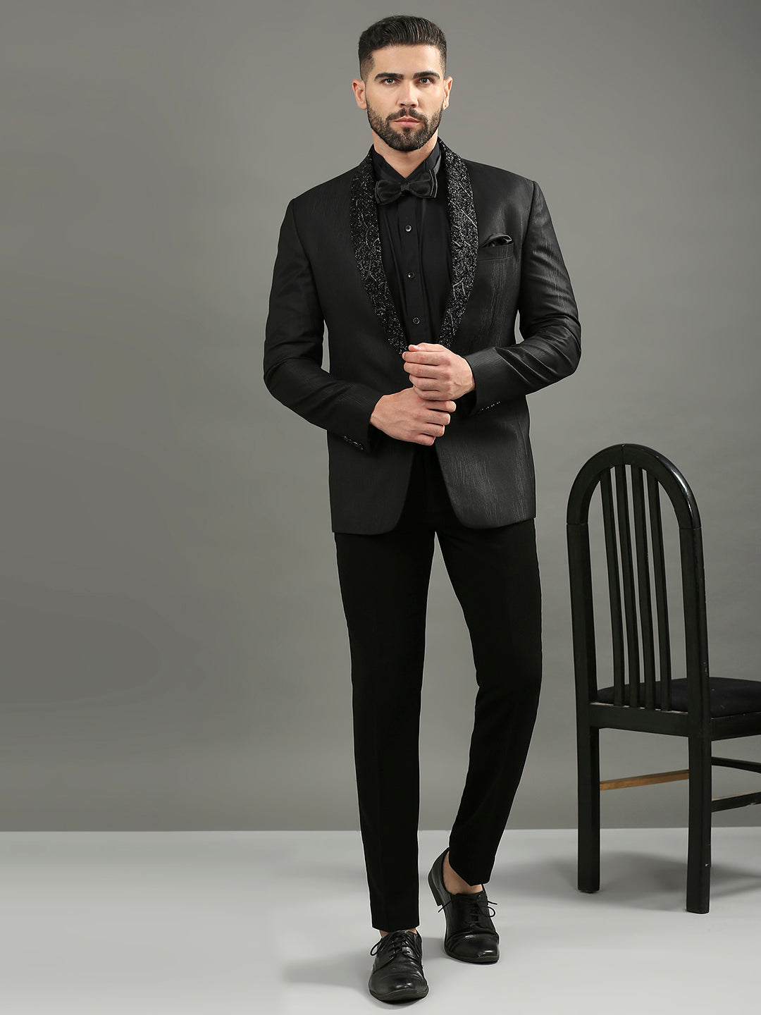Man wearing a black suit with a gray background